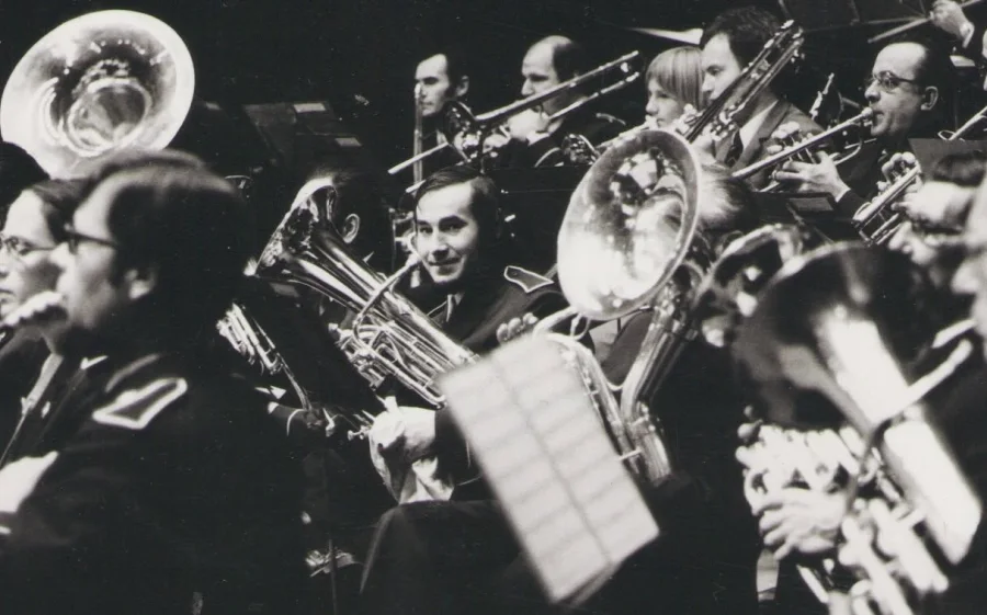 Garcimore jeune, assis au milieu des cuivres d'un orchestre, son tuba sur les genoux