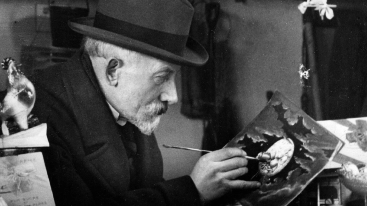 Georges Méliès âgé peignant une illustration de la Lune