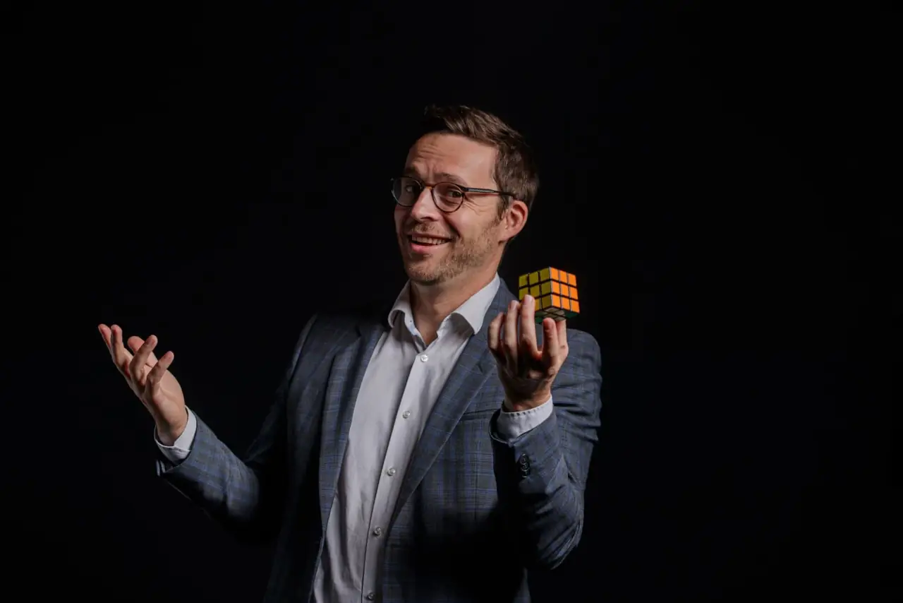 Hugo Marceau, magicien et mentaliste, tenant un Rubik's Cube