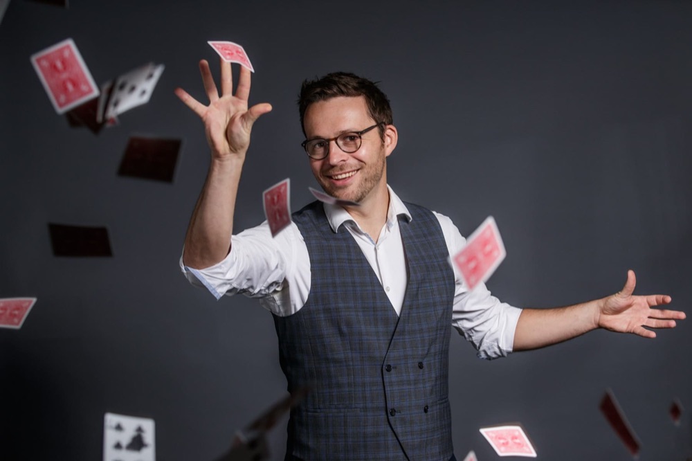 Illusionniste faisant voler des cartes sur scène