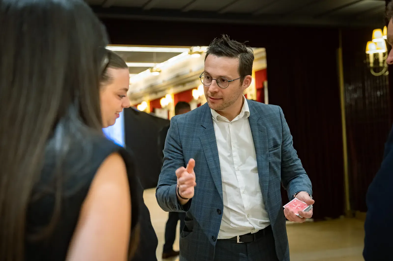 Magicien en close-up pour une soirée de gala d'entreprise, invités captivés
