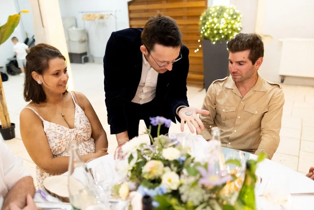 Magicien en close-up de table en table pendant le repas d'un mariage