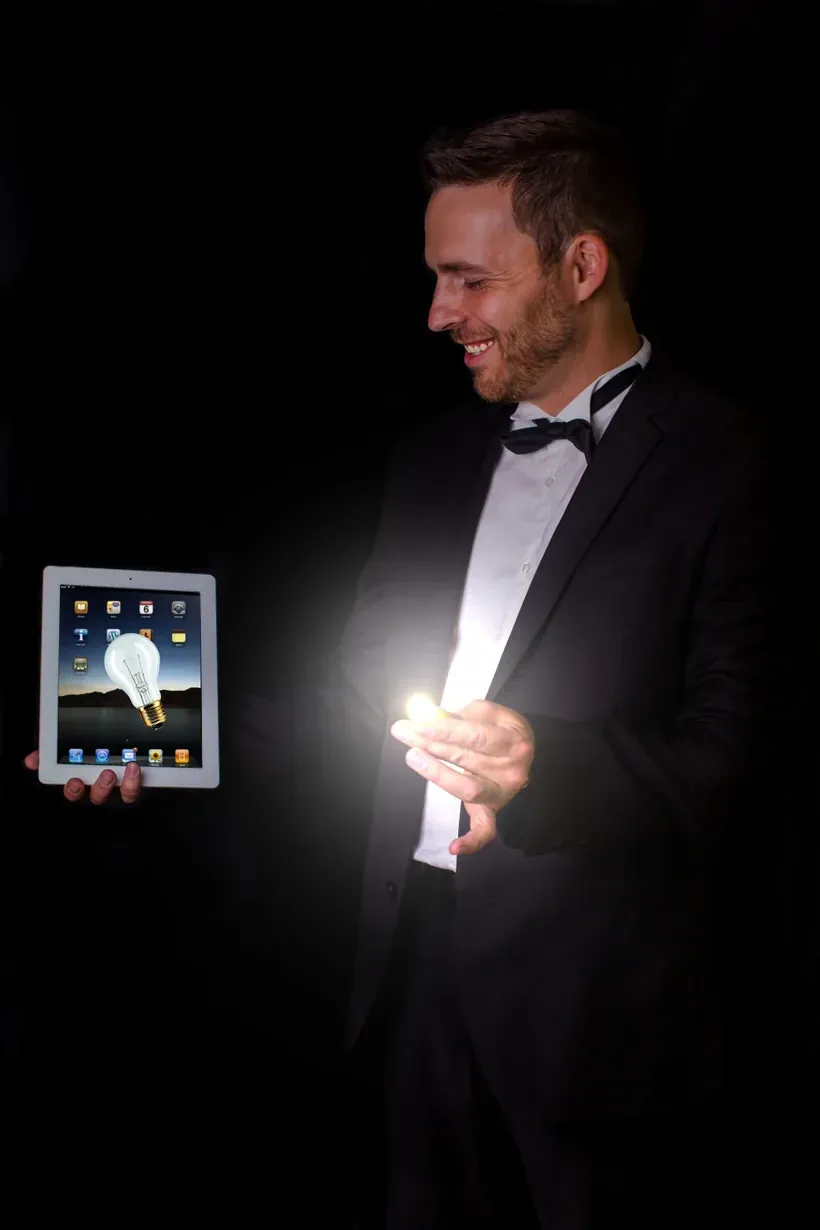 Hugo Marceau en magie digitale sur iPad, une ampoule lumineuse apparaît dans sa main
