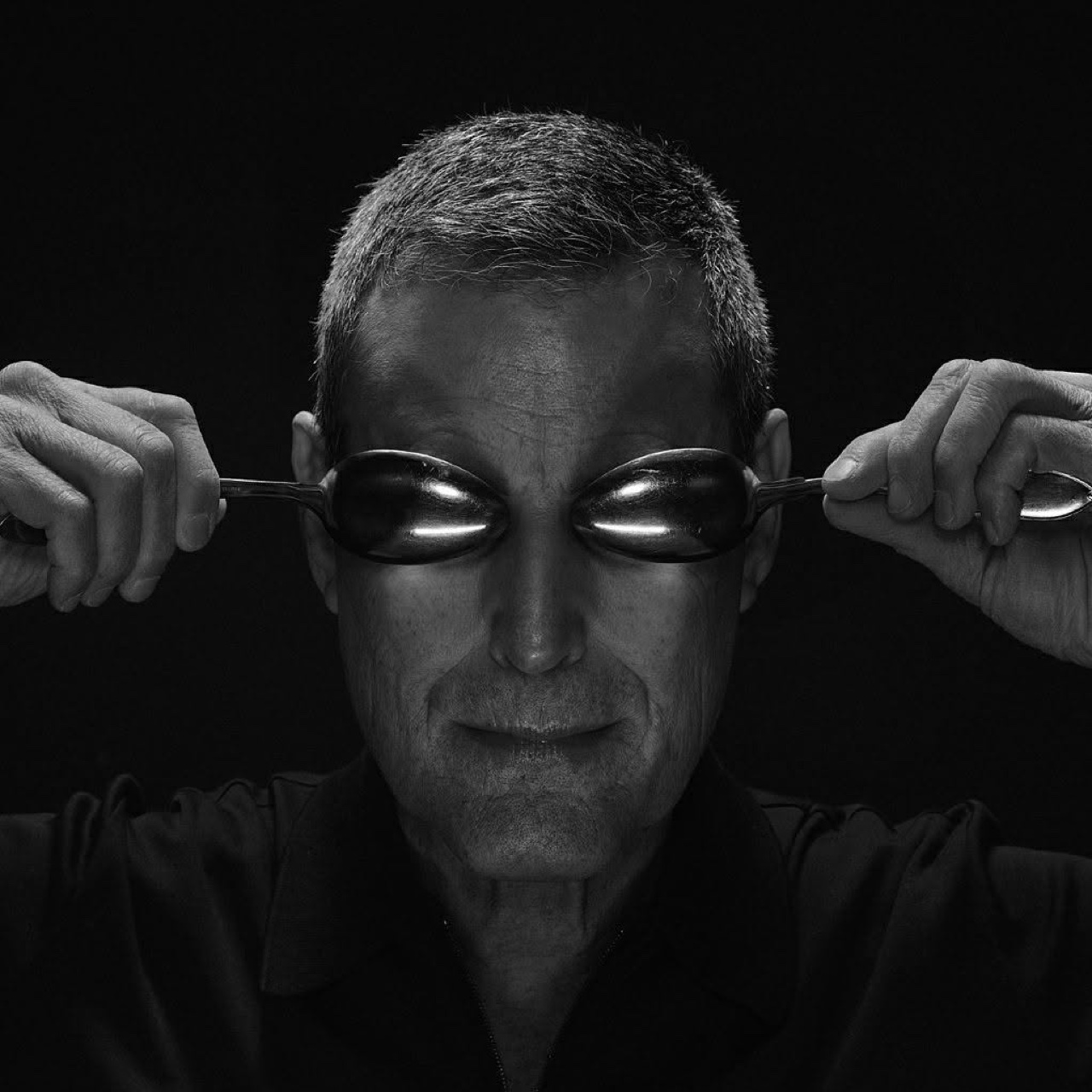 Uri Geller tenant deux cuillères tordues devant ses yeux