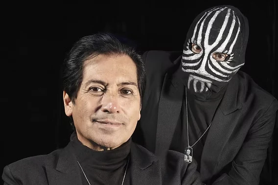 Val Valentino photographié à visage découvert, à côté de son personnage du magicien masqué